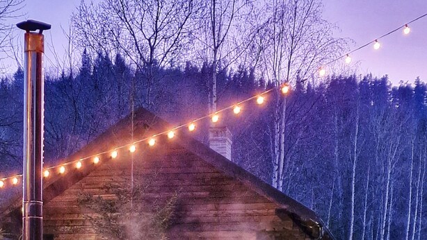 A rustic wooden cabin with a stone foundation, surrounded by a stone pathway and a forested hillside. - Vatra Boiereasca (Cacica)