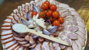 A platter of sliced meats and vegetables. - Vatra Boiereasca (Cacica)
