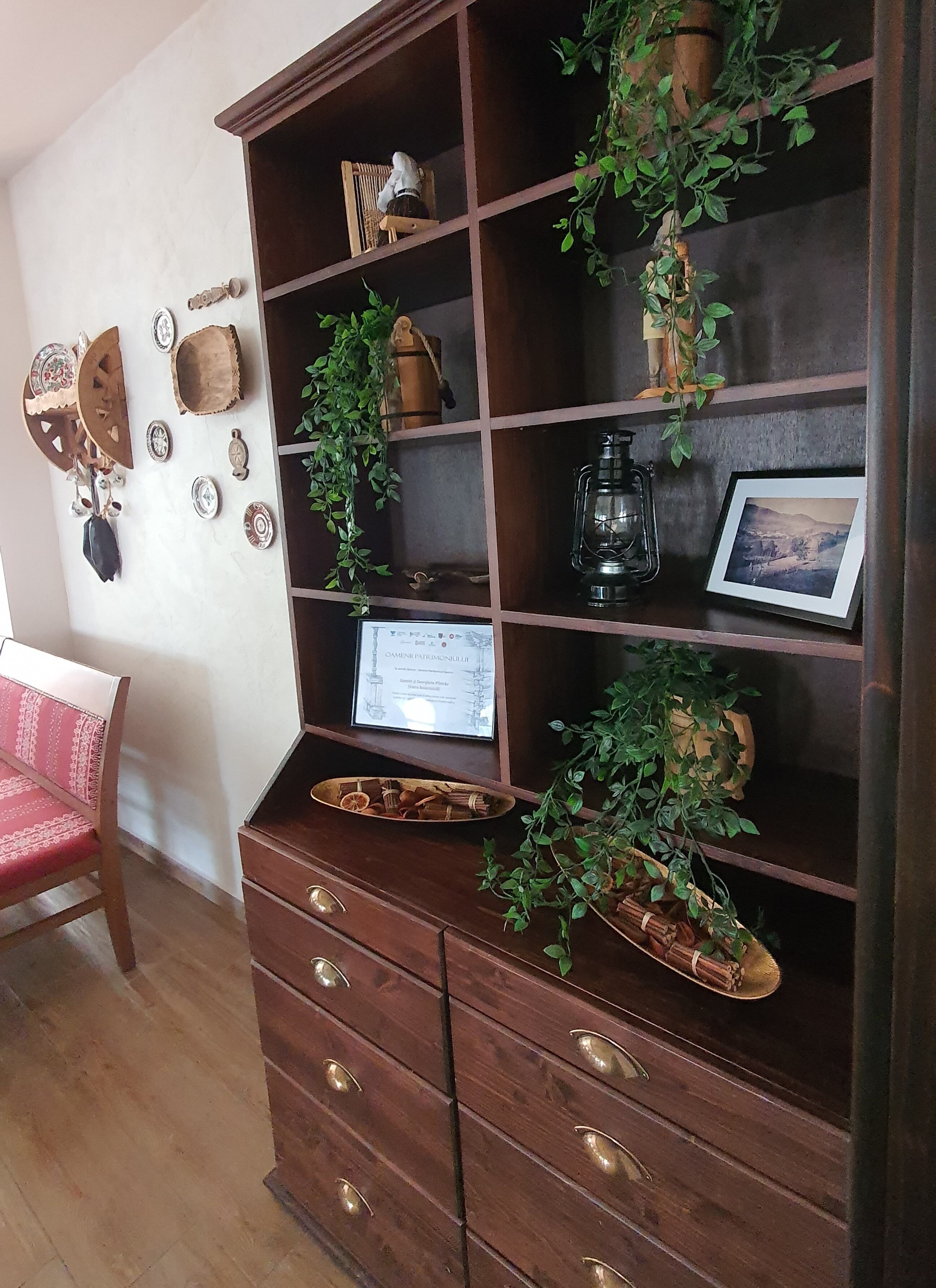 Un mueble de madera con estantes, cajones y un certificado enmarcado.