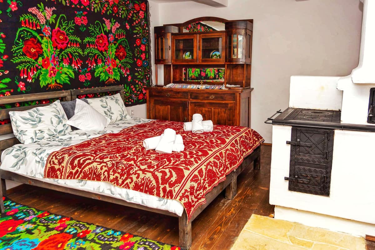 A bedroom with a bed, a wooden dresser, and a tapestry.