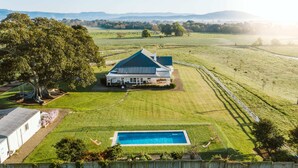 A large house with a swimming pool, surrounded by expansive green fields and a large tree. - 'Mayfield' - Luxury Farmhouse with Pool (Mayfield)