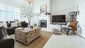 A living room with a fireplace, a television, a sofa, and a coffee table. - 'Mayfield' - Luxury Farmhouse with Pool (Mayfield)