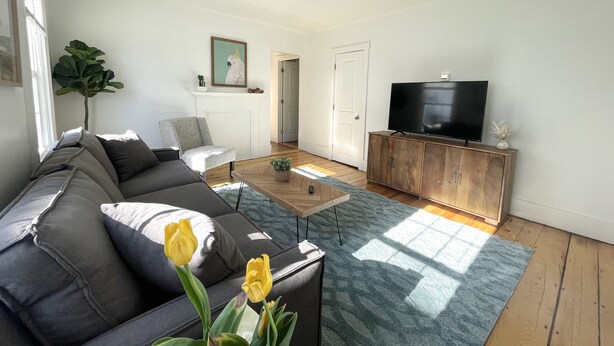 Ein modernes Wohnzimmer mit einer Couch, einem Fernseher und einem Kamin.