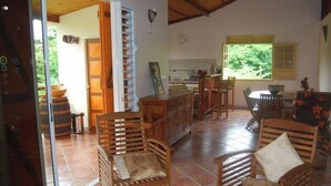 Une cuisine spacieuse, dotée de meubles de rangement en bois et d’un coin repas avec une table et des chaises.