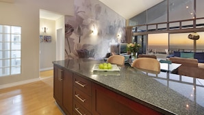 Una cocina moderna con encimera de granito, armarios de madera y un mural floral decorativo.