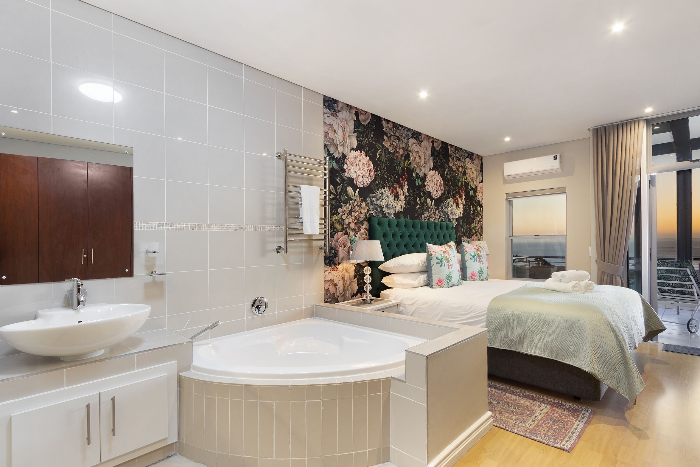 Une salle de bain moderne avec une baignoire sur pieds, un grand miroir et un meuble-lavabo.