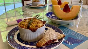 A dining table with a dessert dish, a plate with a fruit slice, and a dessert pastry.