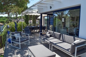 An outdoor deck with a sofa, chairs, and a table. - Beautiful Villa with sea views located 1.5 km from Platja Gran de Pals.  (Pals)