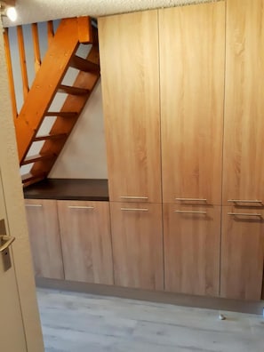 Eine Küche mit Holzausstattung und einer Holztreppe.