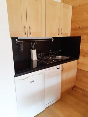 A compact kitchen with a black countertop, a sink, and white cabinetry. - 50m from ski slopes, 1st floor, view ski slopes, balcony, tv, 30m², Les 2 Alpes (Les Deux Alpes)