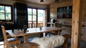 Un interior de madera con una mesa de comedor, bancos y un manto de piel.