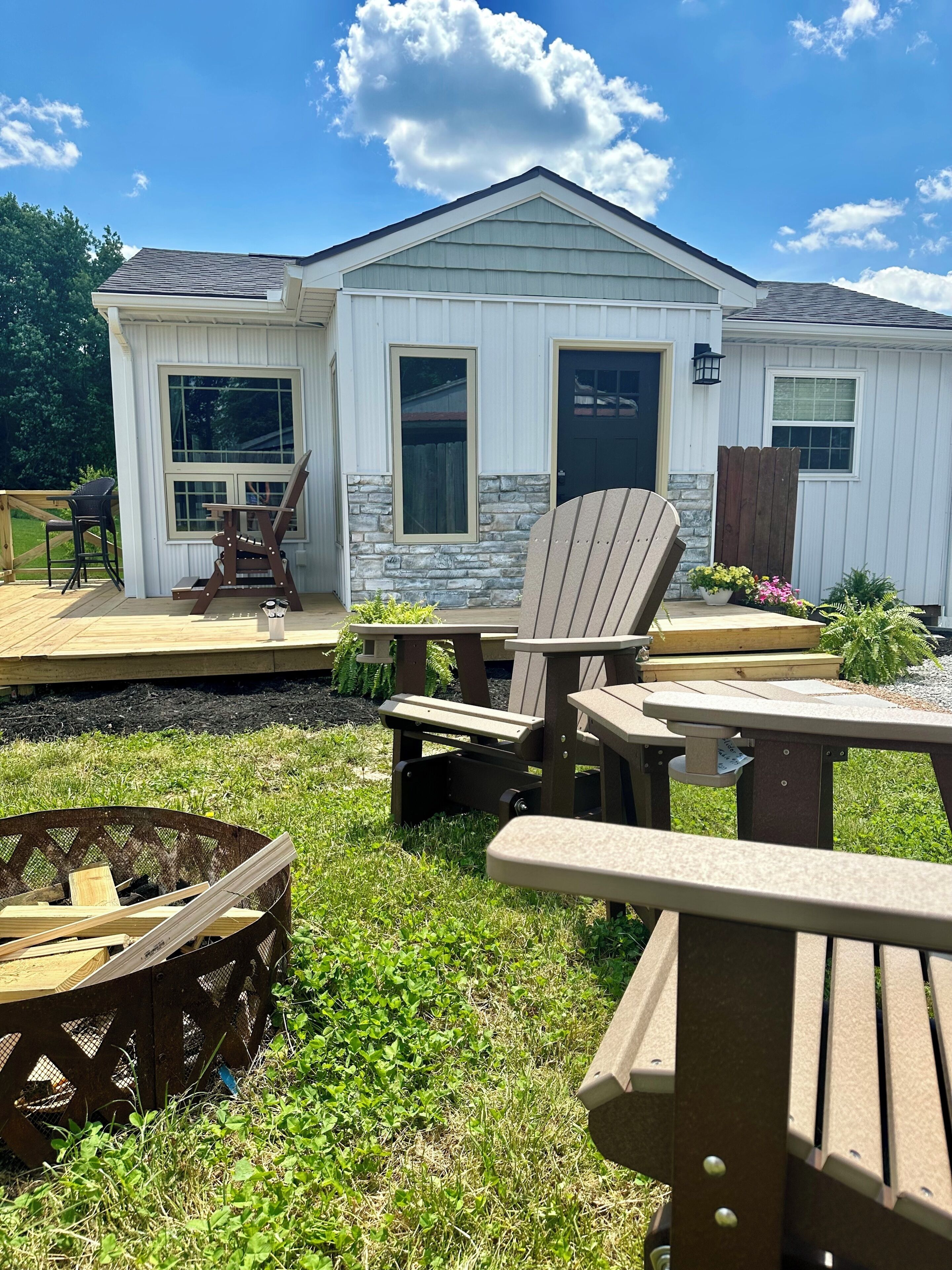 Une maison avec une terrasse, un espace salon extérieur et un foyer.