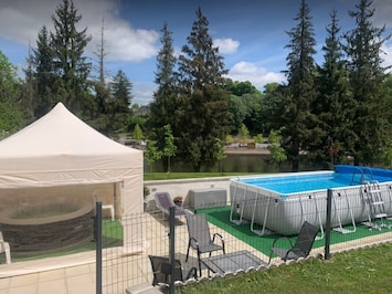 Pool area with hot tub in gazebo and river views