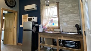 A compact kitchen with a refrigerator, microwave, and built-in oven. There is a window with curtains, a sink, and a wooden countertop. - Toasted Marshmallow (w/fast internet) & baby goats! Farm 20 min to Hocking Hills (McArthur)