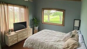 A bedroom with a bed, a TV on a dresser, a window, and a ceiling fan. - Toasted Marshmallow (w/fast internet) & baby goats! Farm 20 min to Hocking Hills (McArthur)