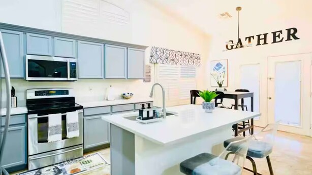 A modern kitchen with a central island, bar stools, a microwave, and a sink. - Mesa 3/2 with Heated pool , RV gate, BBQ (Mesa)