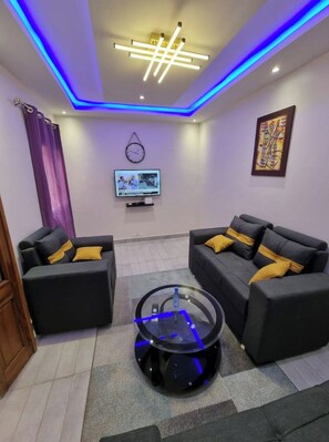 A modern living room with two sofas, a coffee table, and a TV.