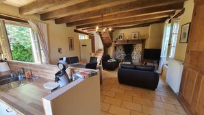 A spacious living area with a fireplace, a dining area with a wooden table, and a kitchen with a modern design. - House (ST MARTIAL DE NABIRAT)