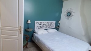 A bedroom with a bed, a nightstand, a lamp, and a decorative wall piece. - House (ST MARTIAL DE NABIRAT)