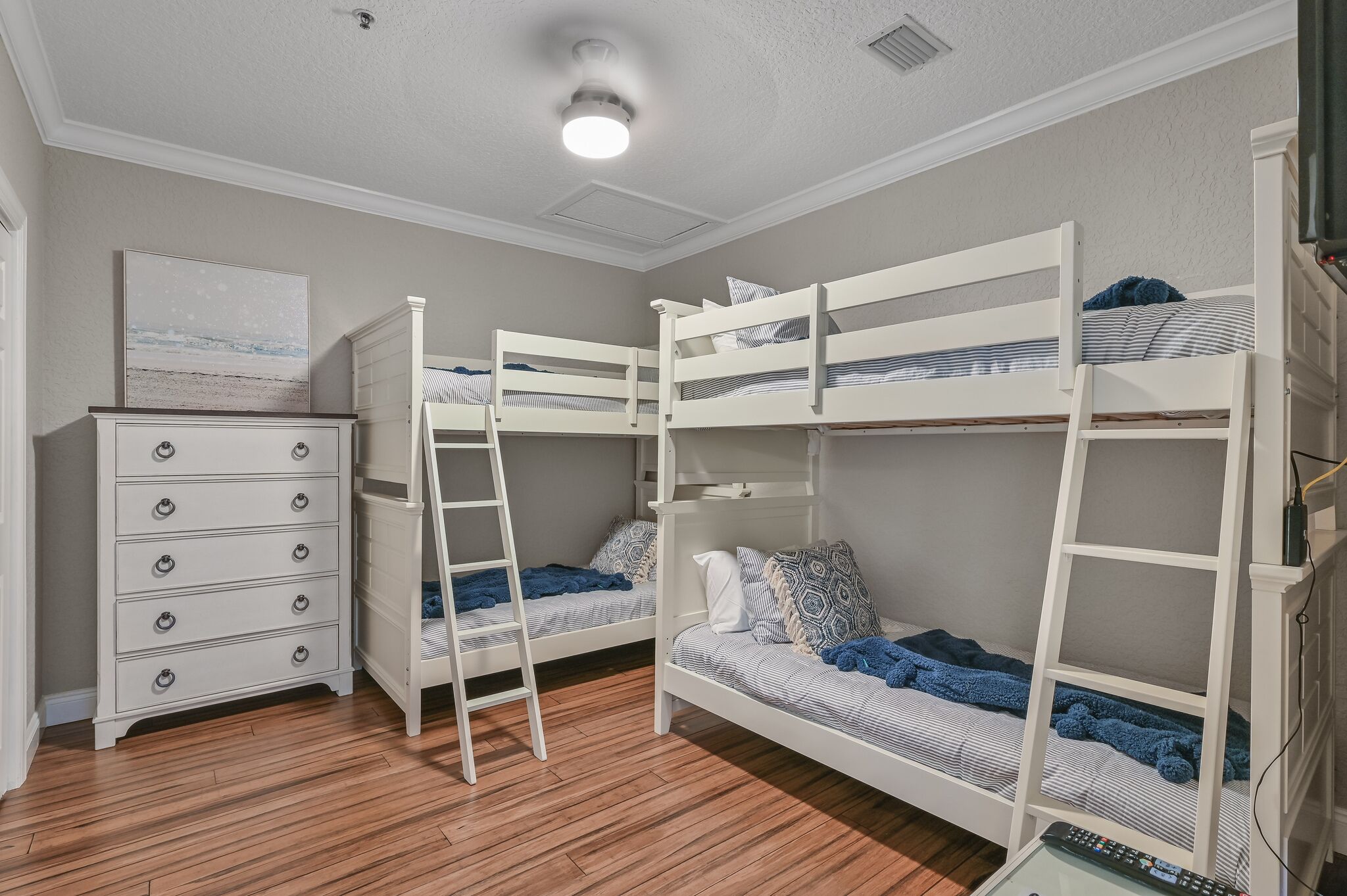 Quarto com beliche, cômoda e escada.