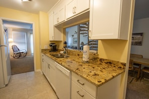 Kitchen area with double sink, coffee maker, and paper towel dispenser.
