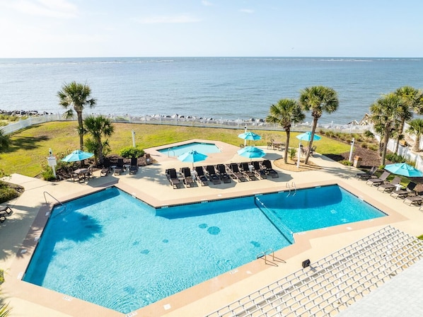 Relax by the ocean-view pool, featuring a separate children's area and comfortable lounge seating.