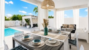 A dining area with a pool view, outdoor seating, and a pergola. - Villa Soave SicilyMyHome (Santa Maria del Focallo)