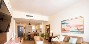 Una sala moderna con un sofá, un comedor y una cocina al fondo.