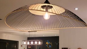 A modern kitchen with a central island, bar stools, and a hanging light fixture. - large pool and jacuzzi villa (Lunel)