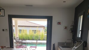 A modern kitchen with a view of a patio and a pool. - large pool and jacuzzi villa (Lunel)