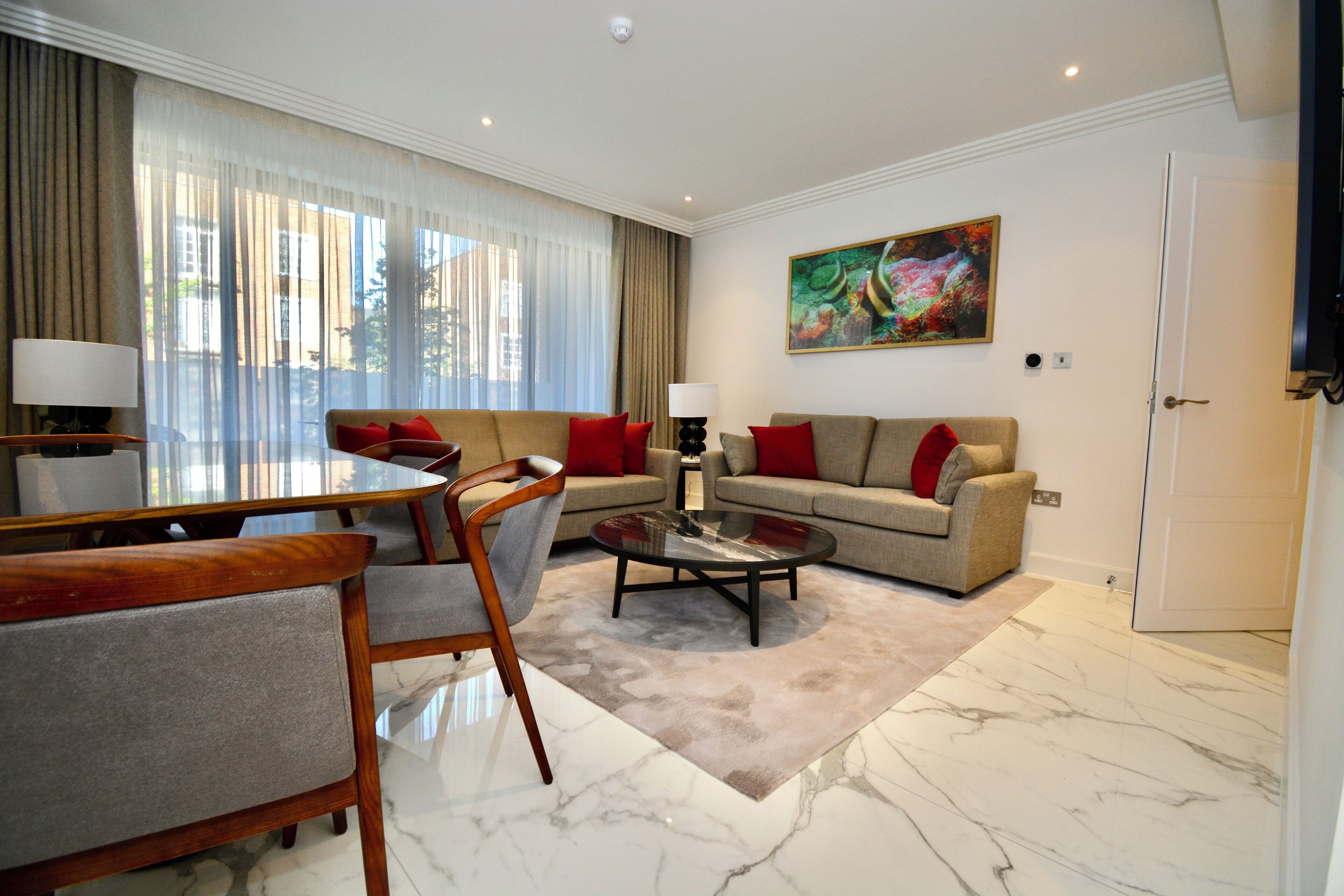 A modern living room with a sofa, armchairs, a coffee table, and a dining area.