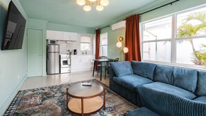 A compact living space with a kitchenette, a sofa, a dining table, and a patterned rug. - 105 · ☀Pool✔ Kitchen✔ Beach✔ Self Checkin✔ Free Parking✔ (Clearwater)