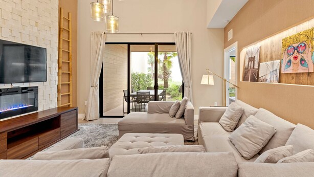 A modern living room with a TV, sofa, and artwork on the wall. - 3045 MagicVillage 8 guests 6 min Disney near 192 (Kissimmee)