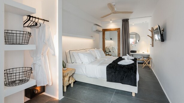 Un dormitorio moderno con cama, mesitas de noche, tocador y ventilador de techo.