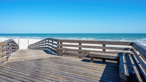 A wooden boardwalk leading to a beach with a clear blue sky. - Amazing bay views from this 4 bedroom 4 bath house (Port Aransas)