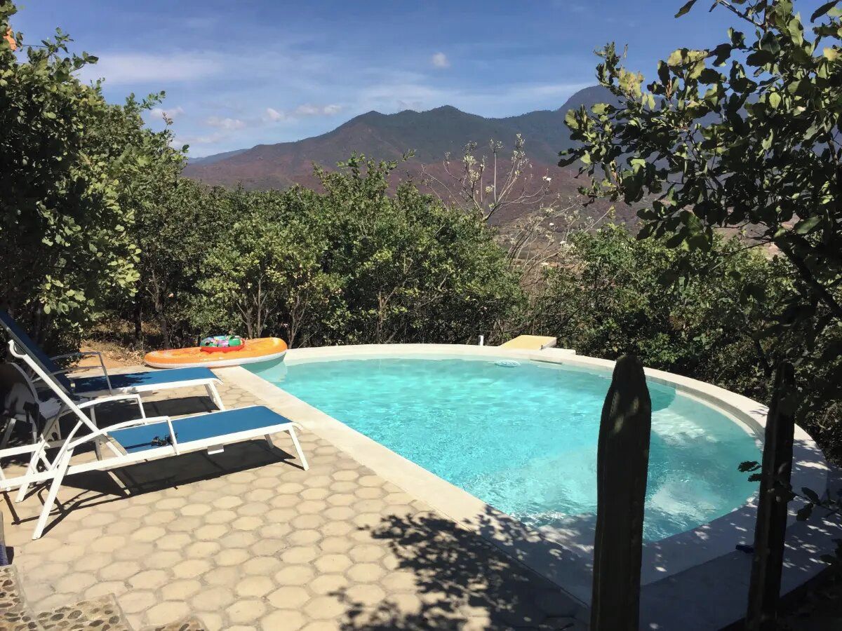 Une piscine avec des chaises longues et une vue sur les montagnes.