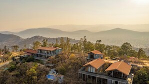 A residential area with houses on a hillside, a swimming pool, and a view of distant mountains. - Casa Utopia (Casa Divina + Horizonte): Divine house in nature close to the city (Oaxaca de Juarez)