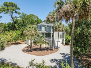 Stroll up to this charming two-story home, surrounded by lush tropical trees and a beautifully manicured driveway.