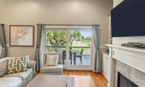 Relax in a cozy living room with a sofa, cushioned bench, and fireplace, offering a serene view of the lush landscape.