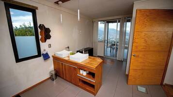 Una cocina moderna con encimera de madera, un lavamanos y una ventana con vistas a la ciudad.