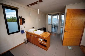 A modern kitchen with a wooden countertop, a sink, and a window overlooking a cityscape. - Utopia Casa Horizonte: a house with a view, and all you need.   (Oaxaca de Juarez)