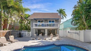 A two-story house with a swimming pool, a covered patio, and a fenced backyard. - Perfect location Walk to the village and beach Private Balcony Heated Pool (Siesta Key)