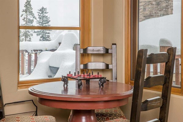 A dining table with a red top and a wooden chair with a metal frame. - Spacious Ski-In/Ski-Out Retreat (Big Sky)