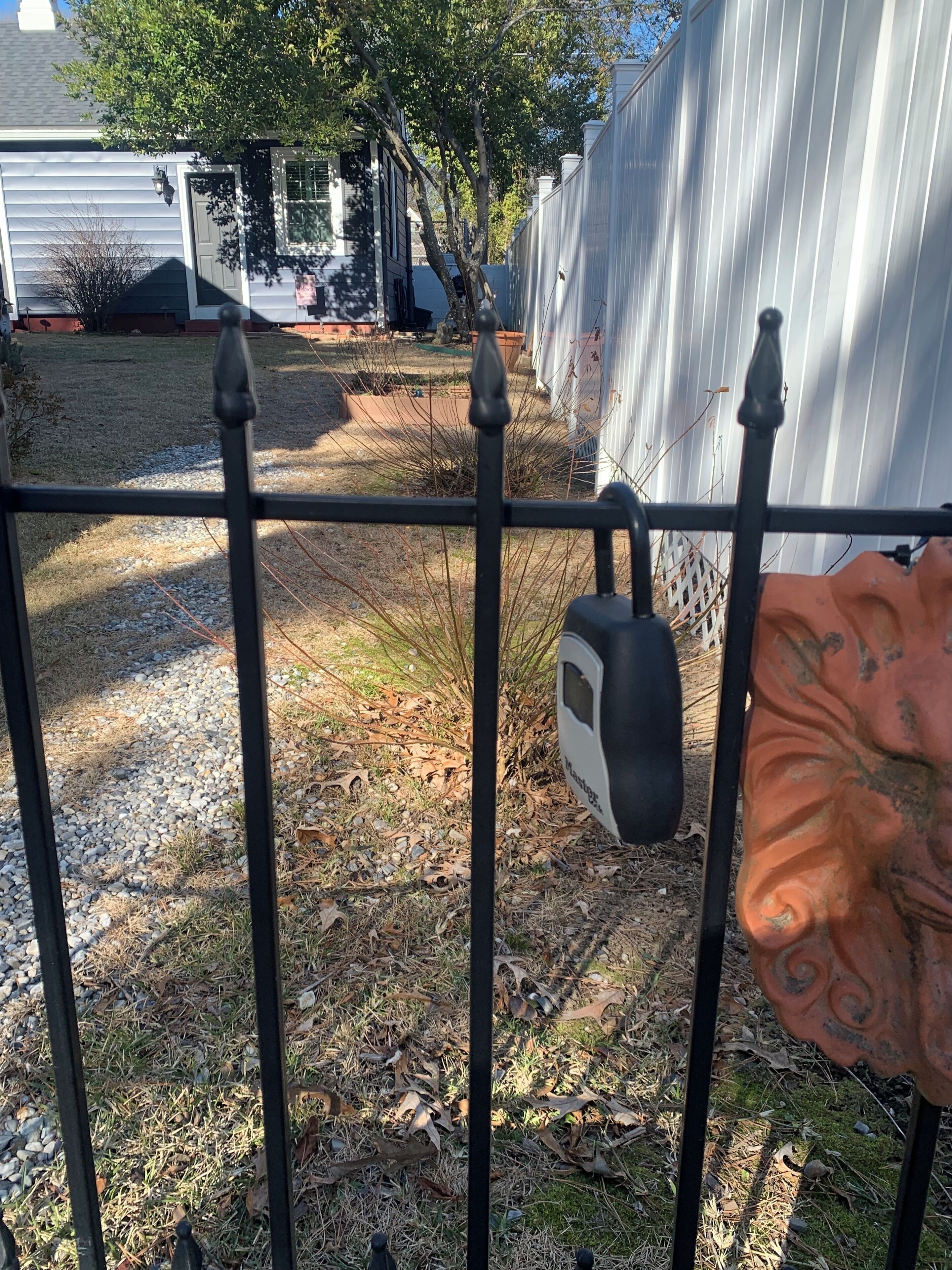 A metal fence with a padlock and a decorative element.