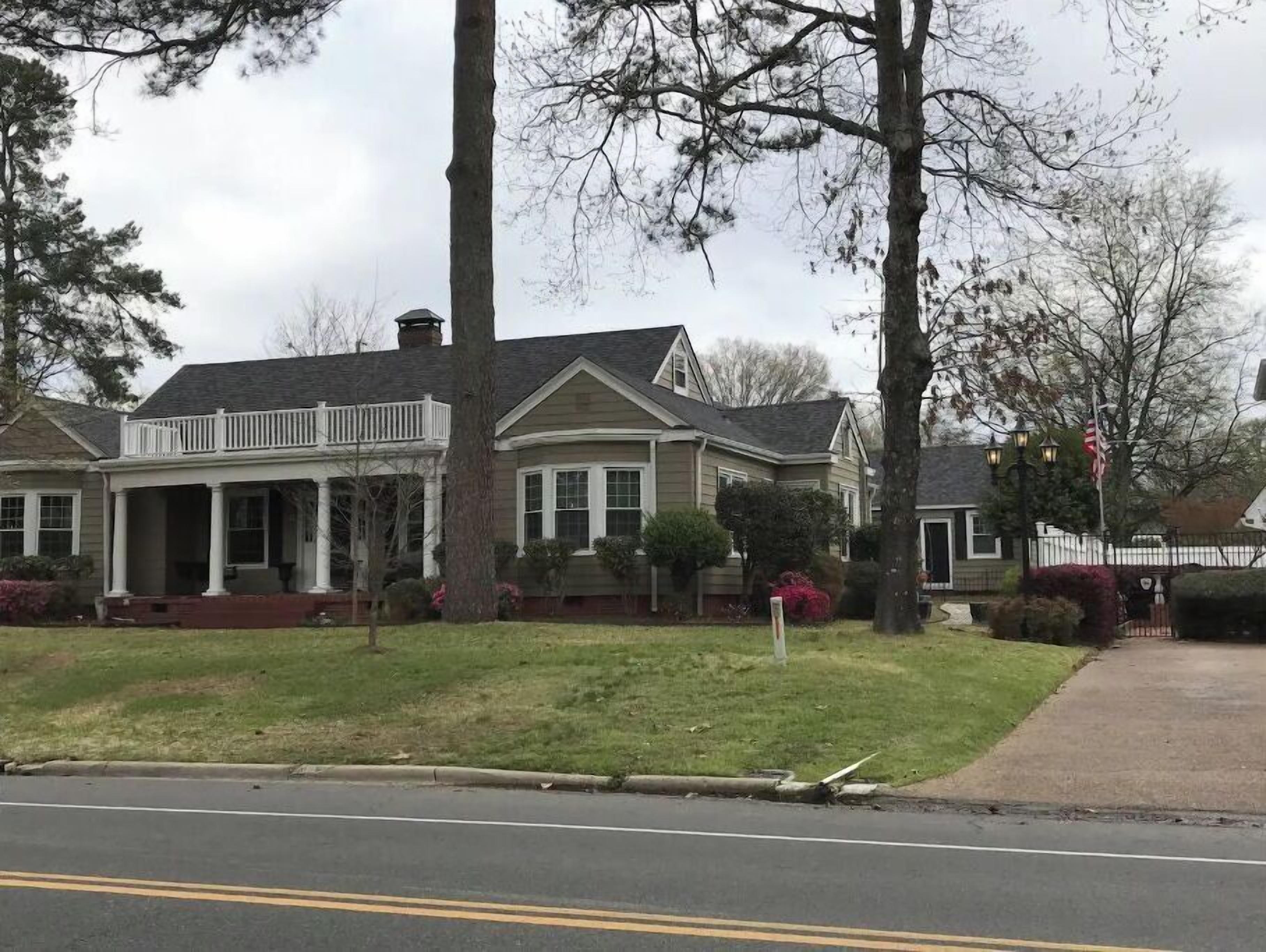 A two-story house with a front porch, a garage, and a well-maintained lawn.