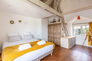 Ein Schlafzimmer mit Bett, Holzschrank und einem fenster mit Vorhängen.