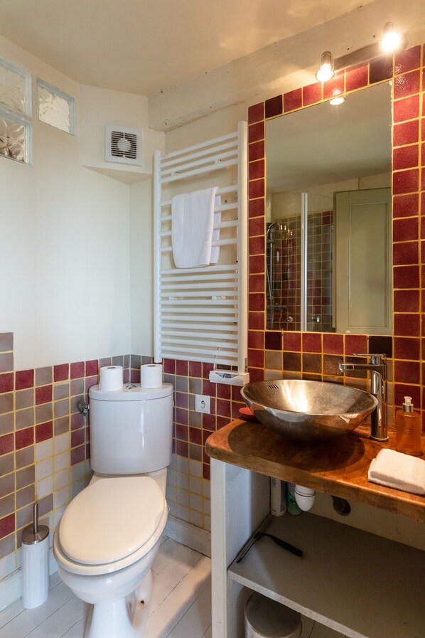 Ein Badezimmer mit Toilette, Waschbecken, Spiegel und Handtuchhalter.