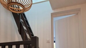 En trappe med et trægelænder og en vævet lampe.