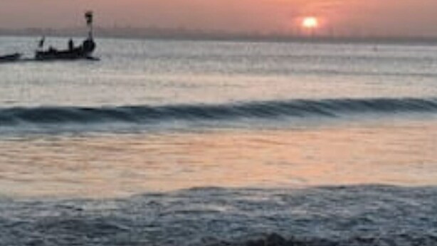 A sunset over a calm sea with a boat in the distance. - Designer apartment (Dakar)