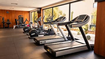 A gym with treadmills, elliptical machines, and weight equipment.